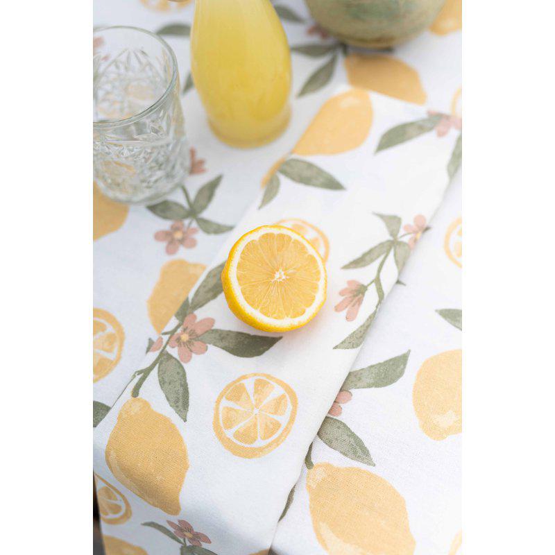 Närbild på duk kallad Amalfi med mönster av citroner från Fondaco på dukat bord.