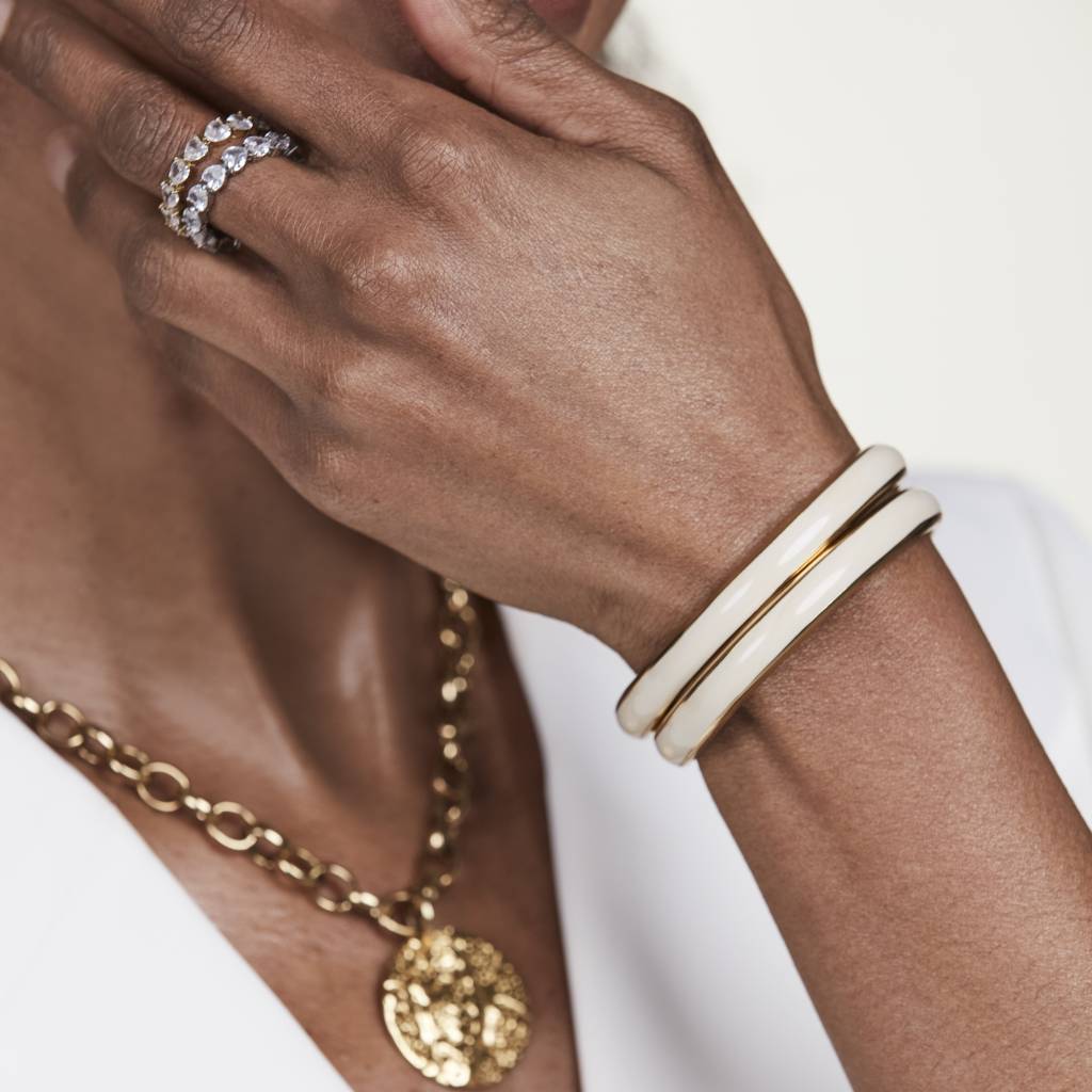 Närbild på kvinna som bär armband Lissabon i guld/sand från by Jolima.