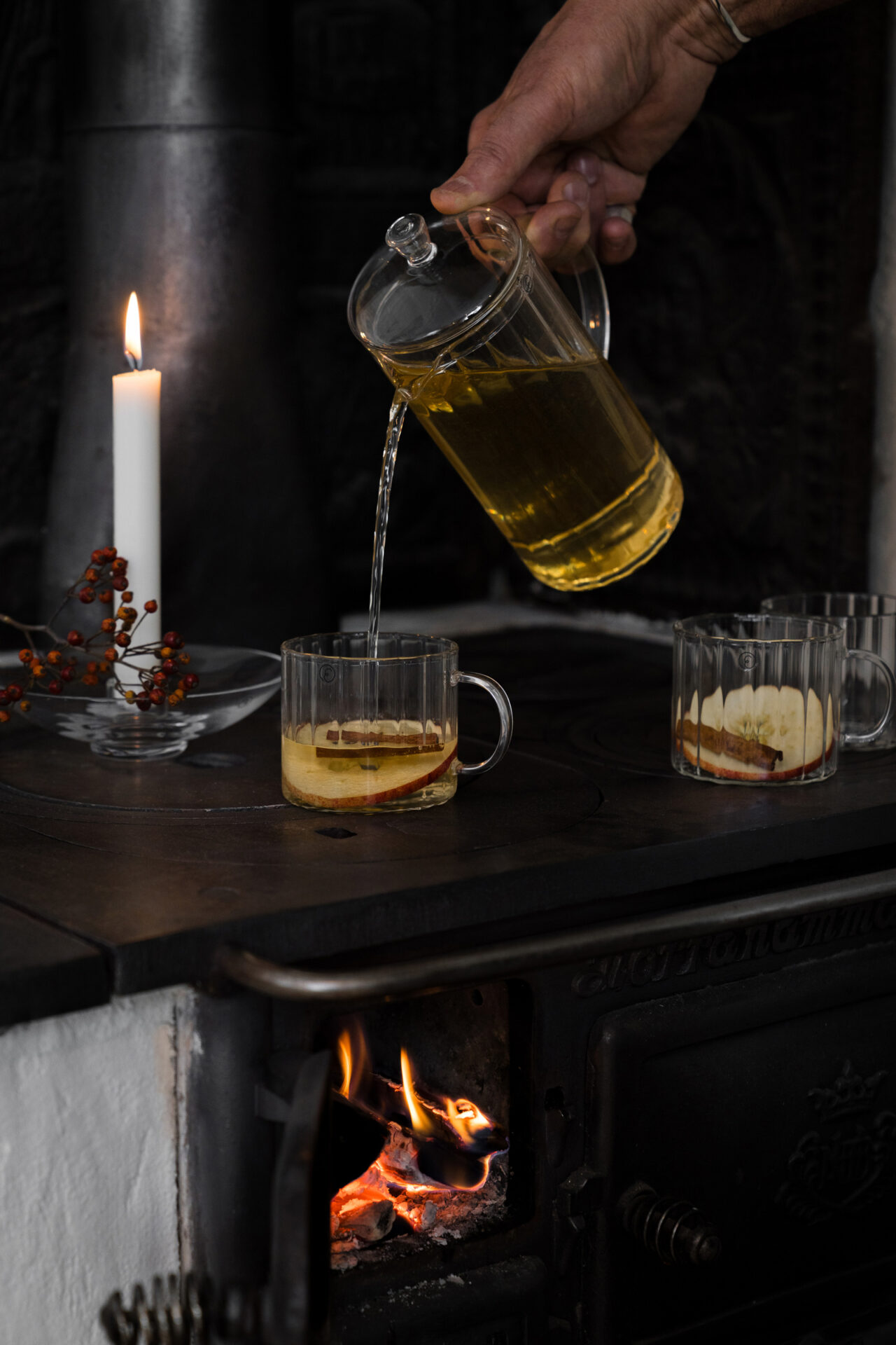 Man häller upp glögg i en glaskopp med en räfflad glaskanna från ERNST.