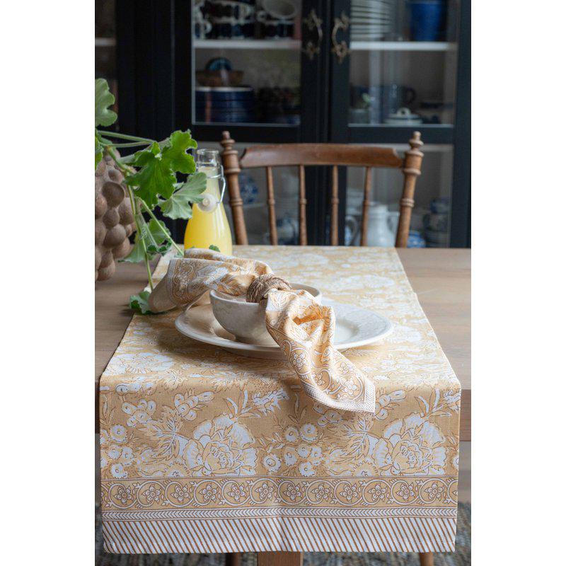Mönstrad löpare Sonia i färgen gul från Fondaco på ett dukat bord.