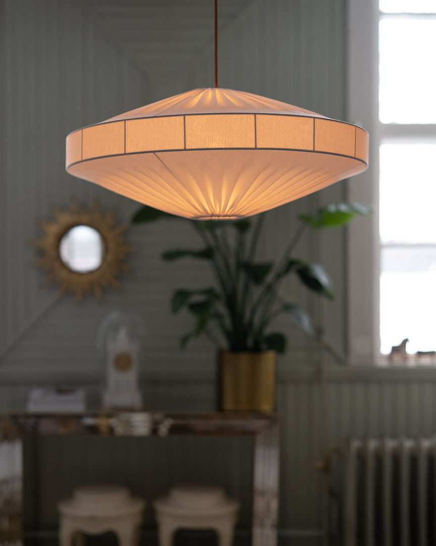 Oval tänd taklampa Alba i vit på 58cm bred från Alde & Lind ovanför ett vardagsrumsbord.